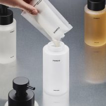 Hand refilling glass Forgo bottle with concentrated soap powder