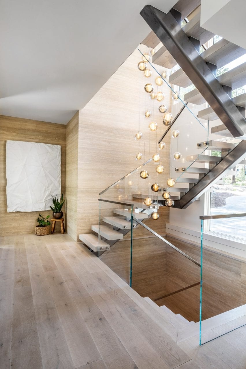 A set of orbed pendant lights handing above a staircase