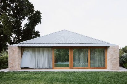 A brick house with a pyramidal roof