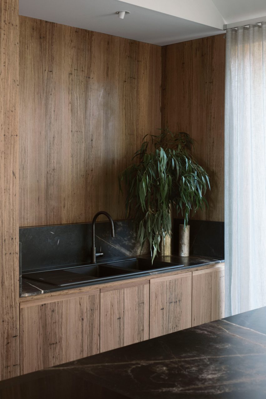 An kitchen with wooden cabinetry and a black sink