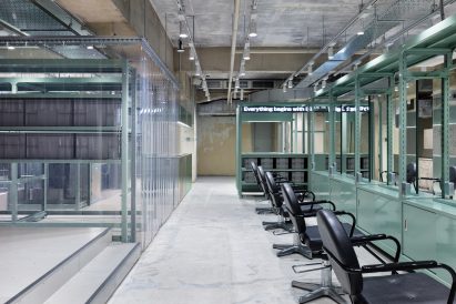 Seafoam green hairdressing stations with black leather seats and clear PVC curtains in Loji hair salon by Schemata Architects