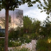 A mirrored pavilion surrounded by gardens