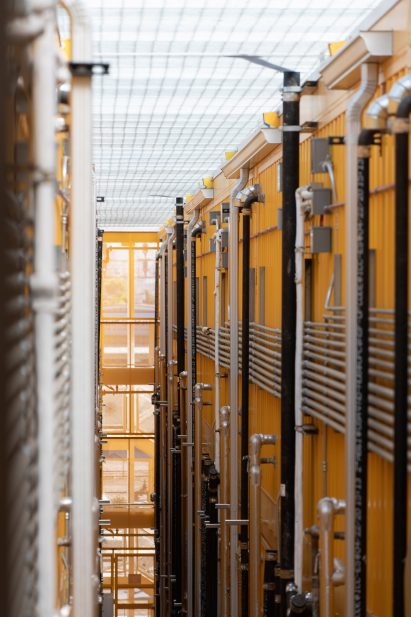 The shipping containers are painted white and bright shades of yellow and orange