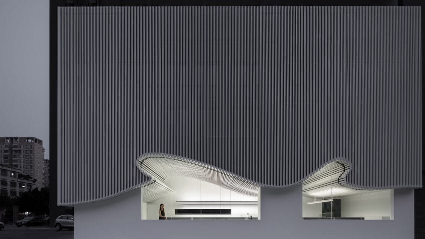 The curved facade stretches across windows