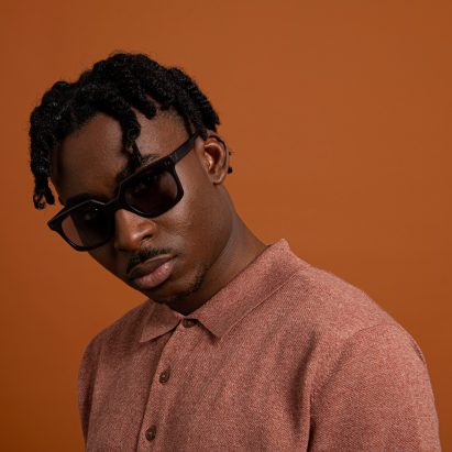 A man wearing Reframd sunglasses and a red shirt