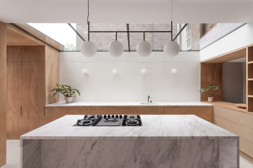 A marble kitchen island and wooden cabinetry