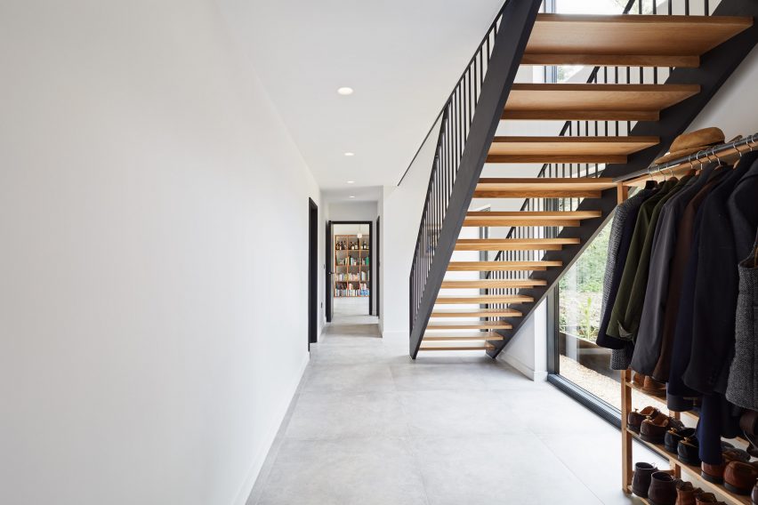 A white-walled hallway with a timber staircase