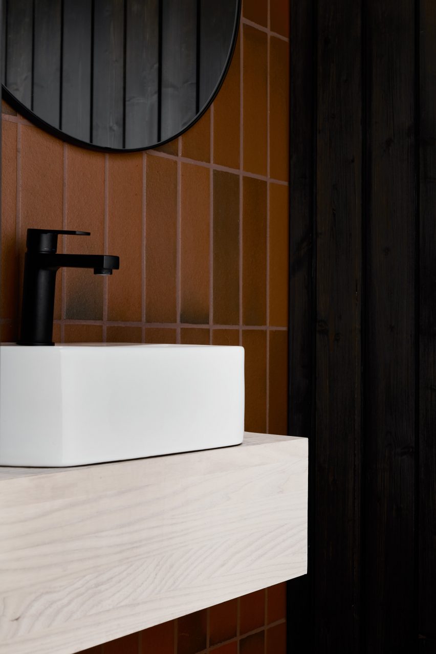 A bathroom with brown wall tiles