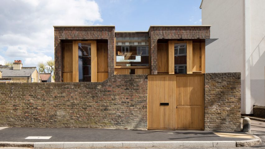 Southwark Brick House peeks above a brick wall in Bermondsey