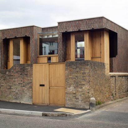 Southwark Brick House peeks above a brick wall in Bermondsey