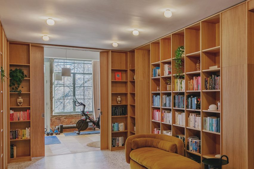 Pocket doors and entrance library in St John Street warehouse apartment by Emil Eve Architects