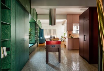 Kitchen with wooden island and built-in green shelves in Trikoupi apartment