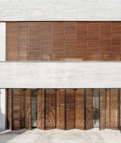 Large rectangular windows punctuate the concrete facade