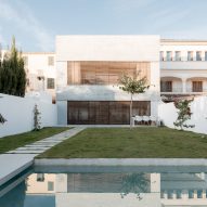 The home is surrounded by a white wall