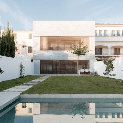The home is surrounded by a white wall