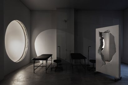 Black leather tattoo beds and mirrored partition in 6:19 Studio