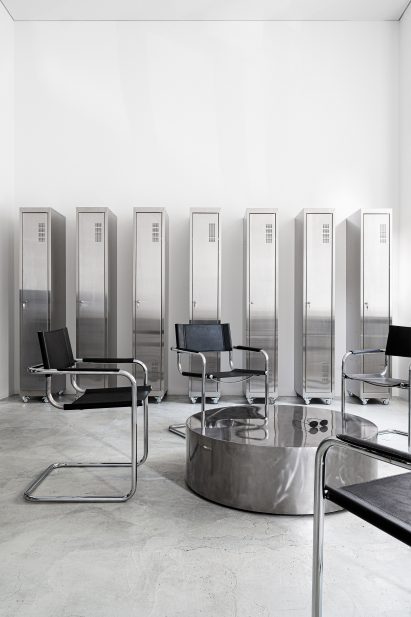 S34 chairs by Mart Stam with cylindrical chrome coffee table and lockers in tattoo parlour by Balbek Bureau