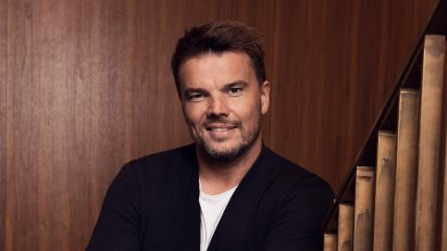 bjarke ingels portrait against wood panelled wall