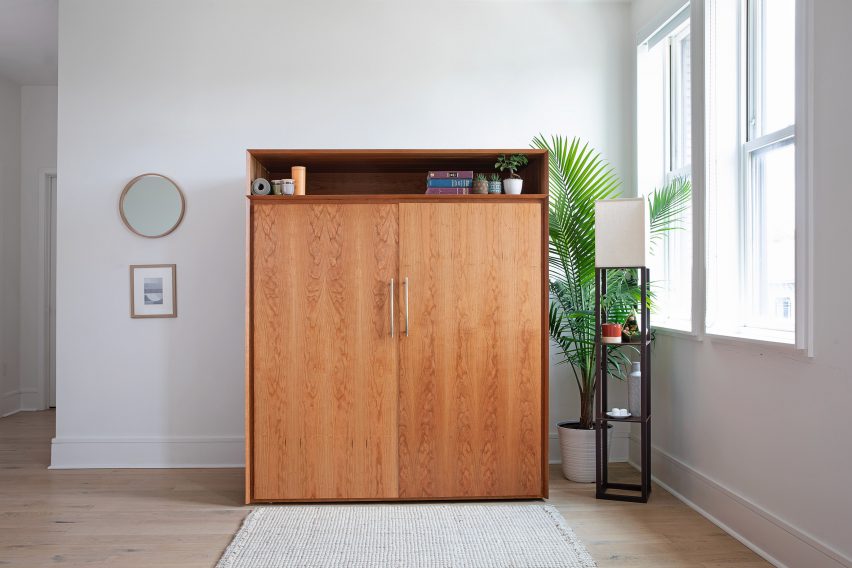 Wooden cabinet in mid-century style in a minimal white apartment hallway