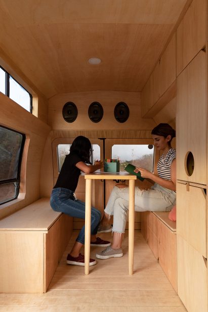 A woman and her daughter sit at a table inside Dodo Van