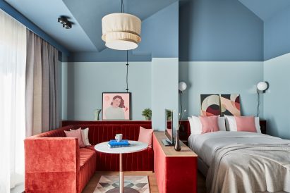 Guest apartment interior by Fettle with two-tone blue walls and red velvet seating nook