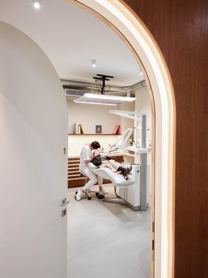 A dentist operated on a patient inside a white dental room
