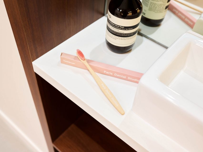 A pair of pink toothbrushes on a white sink