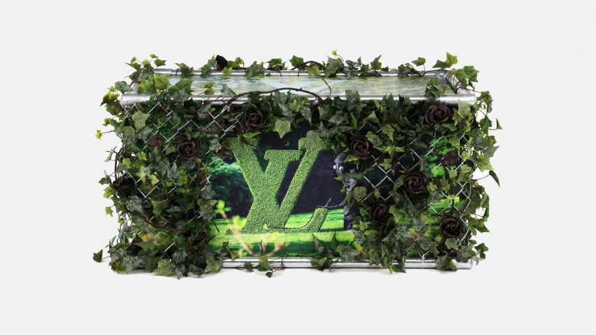 A Louis Vuitton trunk covered in green plants