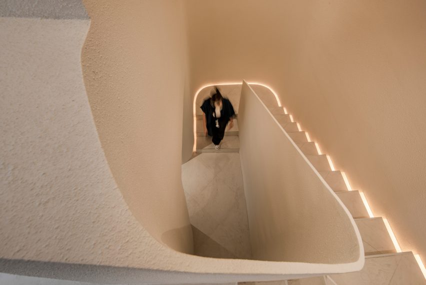 A woman walking up a set of white stairs
