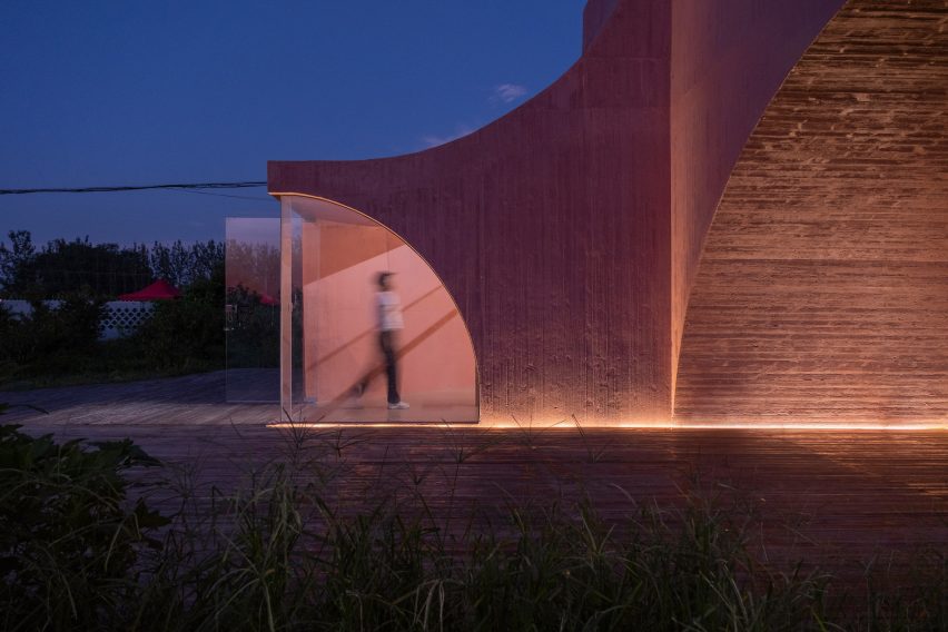 A curved concrete community pavilion
