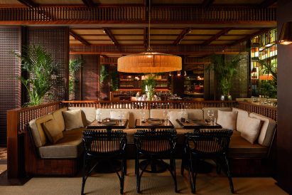 Wooden seating nook with tasseled pendant light in interior by Pirajean Lees