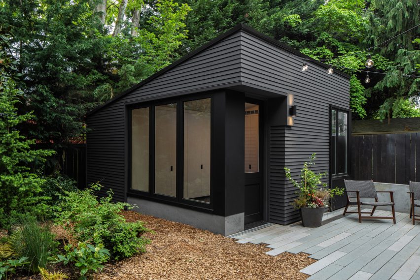 A black timber shed in a garden in Seattle