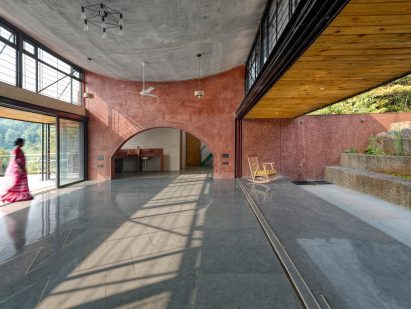 A woman walking through the interior ofThe Cove House