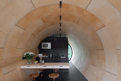 Interior of tube house by Sergey Kuznetsov with wood panelled walls and small kitchen