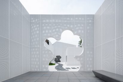 Cloud-shaped cutout in perforated white aluminium facade of Huangyan shop by Wutopia Lab