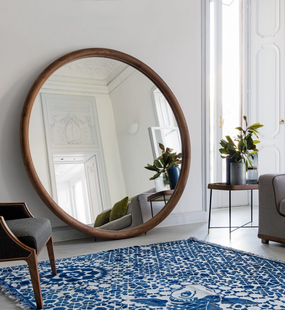 A photograph of a round wooden mirror