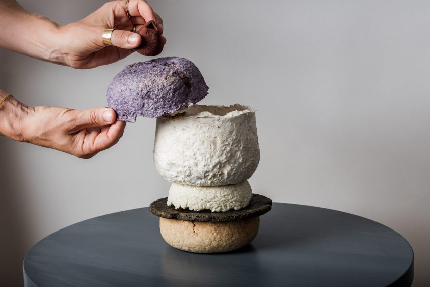 A pair of hands places a bowl on top of a set of bowls by Studio Gollackner