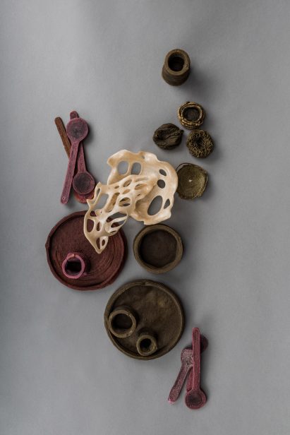 Wasteware plates, bowls and cutlery laid out on a grey surface