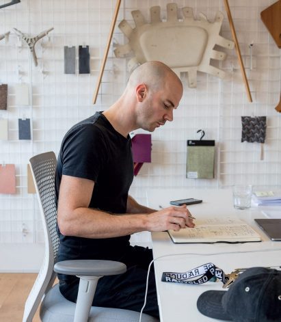 Benjamin Hubert sat at a desk with a notebook