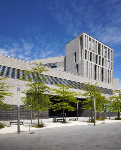 The building is pictured surrounded by young trees