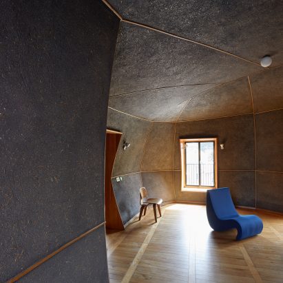 A blue chair inside a room covered in Arakabe clay plaster
