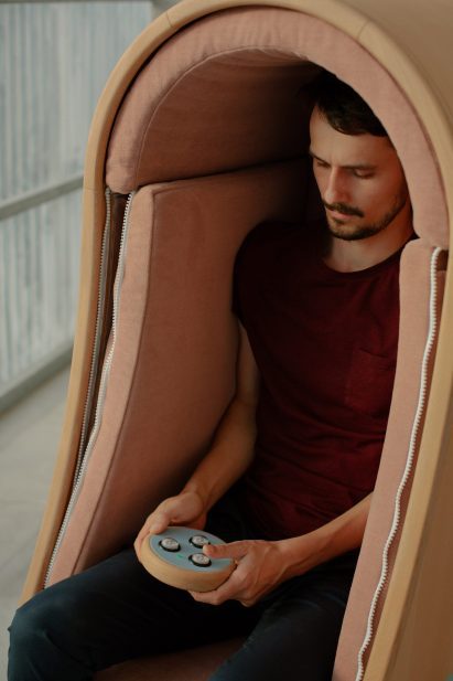 Person controlling Oto hugging chair via remote control