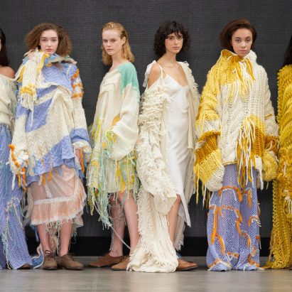 Six models lined up dressed in pastel coloured knitwear