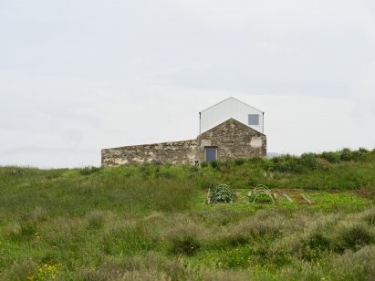 A gabled house slotted within an old farm building