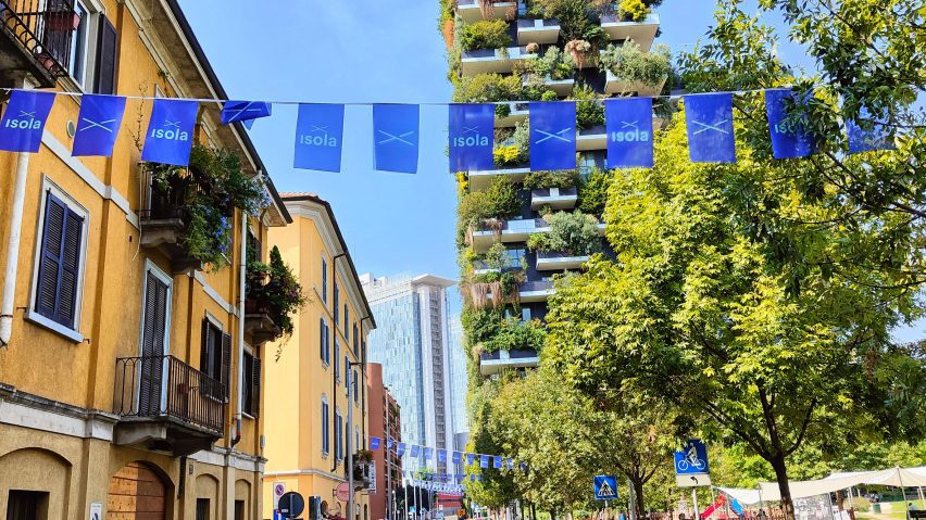 Blue flags hanging across a sunny street at Isola Design Festival