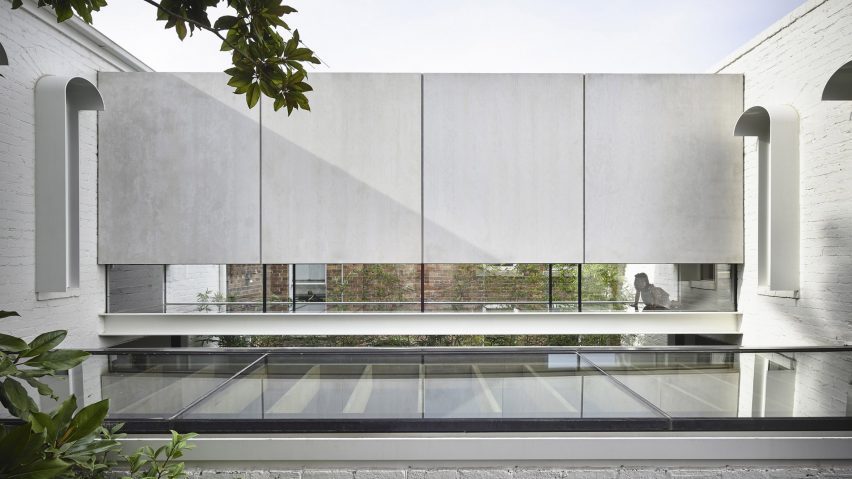 A glass bridge connects the volumes