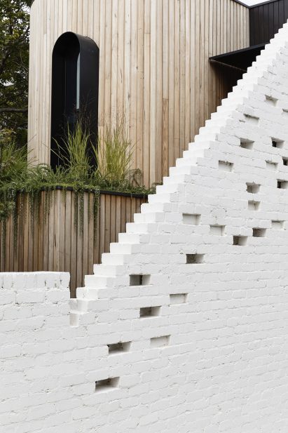 Behind the painted brick wall is a timber structure