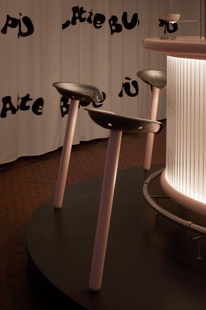 Stools with pink stems and metal tractor seats in installation by Lolita Gomez and Blanca Algarra Sanchez