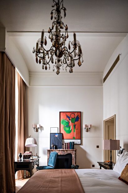 Hotel room by Roman and Williams with fireplace and art on the wall