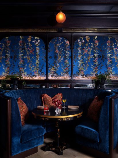 Dining room by Roman and Williams with blue velvet wallpaper